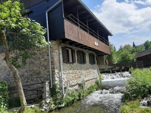 um edifício ao lado de um rio ao lado de uma casa em Sobe Ivan Rastoke 21 em Slunj