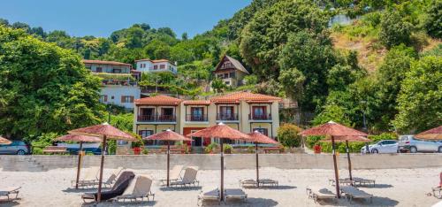 a group of chairs and umbrellas on a beach at Pelagos Hotel in Agios Ioannis Pelio