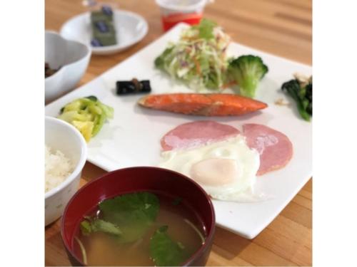 un plato de comida con carne y verduras en una mesa en Minshuku Cress - Vacation STAY 48357v, en Biei