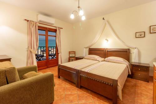 a bedroom with a bed and a chair and a window at Pelagos Hotel in Agios Ioannis Pelio