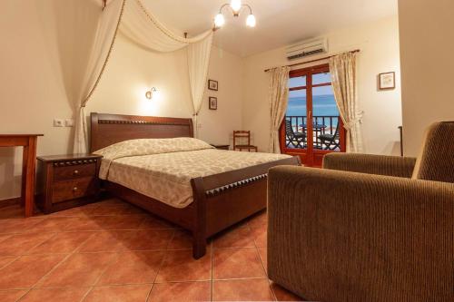 a bedroom with a bed and a couch and a window at Pelagos Hotel in Agios Ioannis Pelio