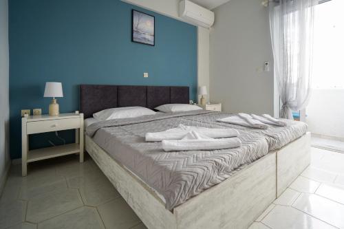 una camera da letto con un grande letto con asciugamani bianchi di Amvrosia Apartments a Mastichárion