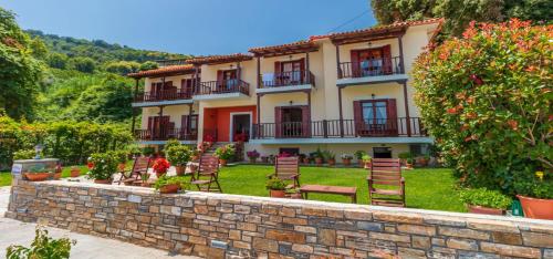 a building with chairs in front of a wall at Pelagos Hotel in Agios Ioannis Pelio