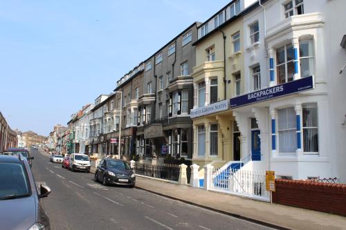 una calle con edificios y coches estacionados en la calle en Backpackers Blackpool - Family Friendly Hotel, en Blackpool