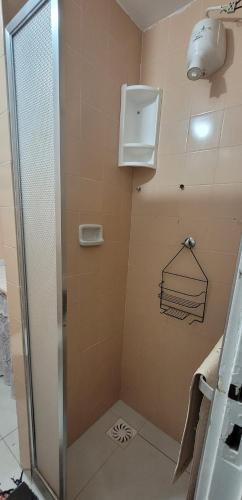 y baño con ducha y puerta de cristal. en CABO FRIO Praia do Forte Fte Mar charmoso 2 qtos 7 pessoas, en Cabo Frío