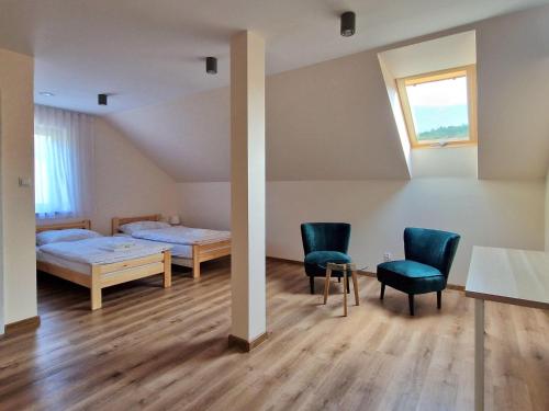 1 dormitorio con 1 cama, 2 sillas y mesa en Comfortable holiday home with a swimming pool for 12 people en Iwierzyce