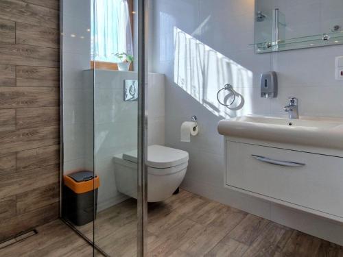 a bathroom with a toilet and a sink at Comfortable holiday home with a swimming pool for 12 people in Iwierzyce