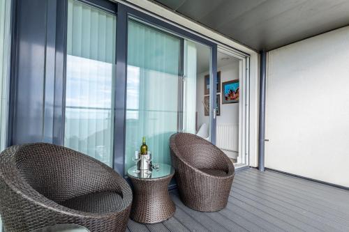 2 rieten stoelen en een tafel op een balkon bij Seaview West Coast in Bournemouth