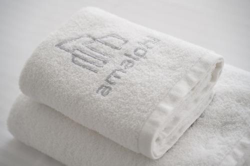 a stack of white towels with the words fail on them at AMALPHI Corfu City Living in Corfu