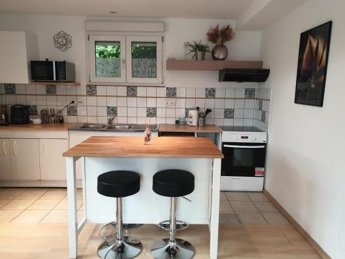 a kitchen with a table and two stools at Appartement proche d'Europa park/Marchés de Noël in Rhinau