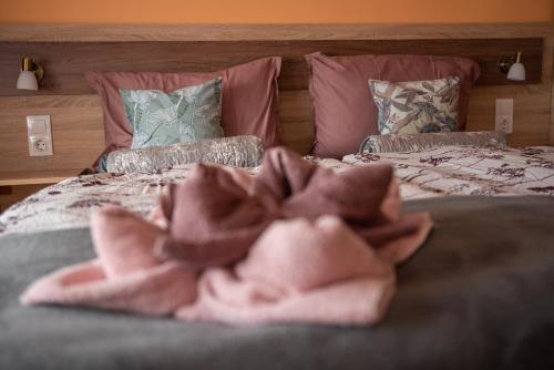 two beds with pink towels on top of them at Benige vendégház in Demjén