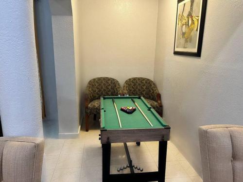 a room with a pool table and two chairs at Amazing & cozy Duplex near Zoo Miami ! in Miami