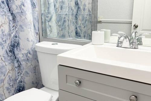 a bathroom with a toilet and a sink and a mirror at Amazing & cozy Duplex near Zoo Miami ! in Miami