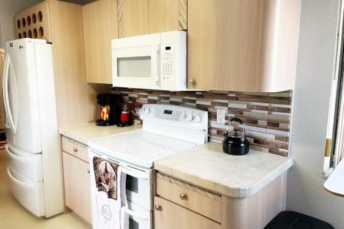 a kitchen with a white stove and a refrigerator at Amazing & cozy Duplex near Zoo Miami ! in Miami