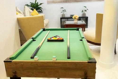 a pool table with two cuesticks on top of it at Amazing & cozy Duplex near Zoo Miami ! in Miami