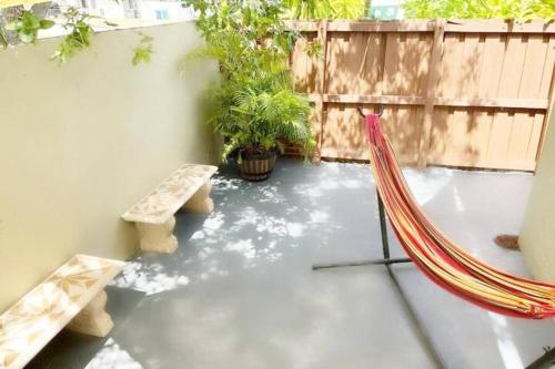 a patio with a hammock and a wooden fence at Amazing & cozy Duplex near Zoo Miami ! in Miami