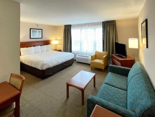 バーリントンにあるSmart Suites, Ascend Hotel Collectionのベッドとソファ付きのホテルルーム
