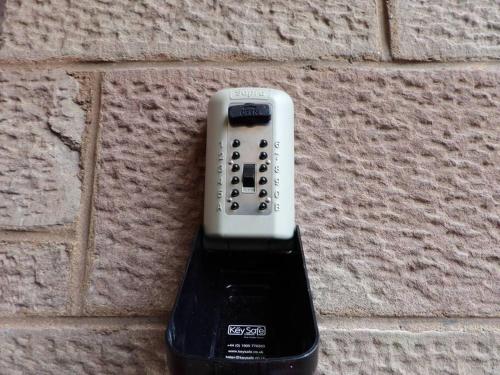 a remote control hanging on a brick wall at 3 Bedroom villa attached to Host home free parking in Perth