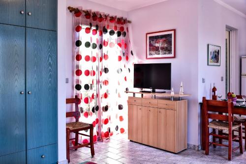a living room with a curtain with red and white polka dots at Aeolos Studios Kefalonia in Khelmáta