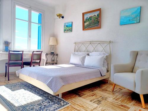 a bedroom with a bed and a couch and a chair at Sea view studio terrasse Cap Martin/Monaco in Roquebrune-Cap-Martin