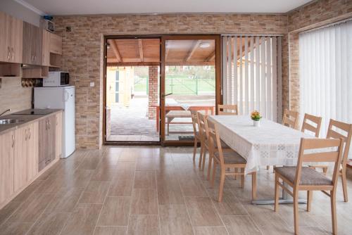 eine Küche und ein Esszimmer mit einem Tisch und Stühlen in der Unterkunft Benige vendégház in Demjén
