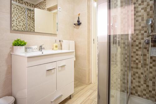 uma casa de banho com um lavatório e um chuveiro em casa saloia na Nazaré