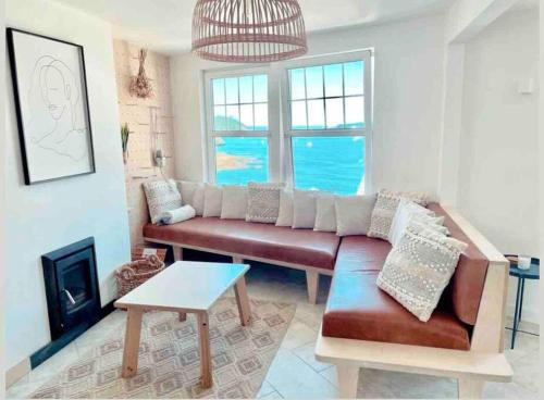 a living room with a couch and a fireplace at The View, Kingsand, luxurious seafront penthouse apartment with sun trap balcony and incredible sea views in Kingsand