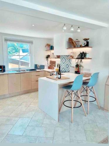 a kitchen with a table and two chairs in it at The View, Kingsand, luxurious seafront penthouse apartment with sun trap balcony and incredible sea views in Kingsand