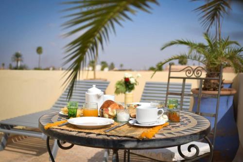 a table with food and drinks on a patio at RIAD DAR NAOMI in Marrakech