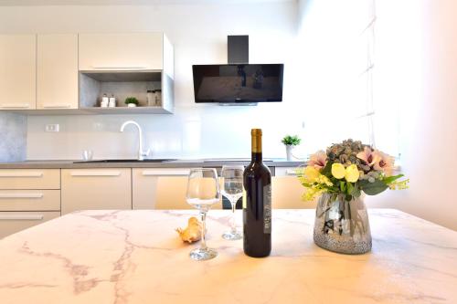 a bottle of wine and two glasses on a table at Apartman MAIA in Split
