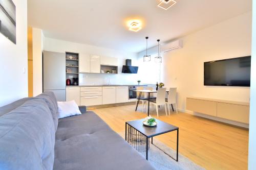een woonkamer met een bank en een tafel en een keuken bij Apartman MAIA in Split