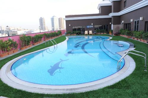 a large swimming pool on the roof of a building at Ascot Hotel in Dubai