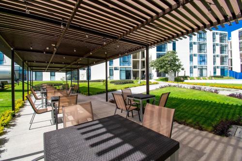 a patio with tables and chairs under a pergola at Departamento Tipo Loft, zona ajijic. in Jocotepec