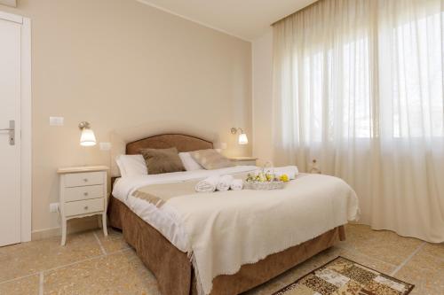 a white bedroom with a large bed and a window at Da Rita Affittacamere in Pisa