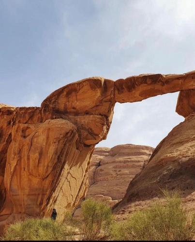an arch in the rocks in the desert at غرووب وادي رم in Wadi Rum