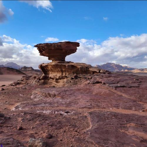 a rock formation in the middle of the desert at غرووب وادي رم in Wadi Rum