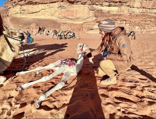 a man and a woman with a dog in the desert at غرووب وادي رم in Wadi Rum