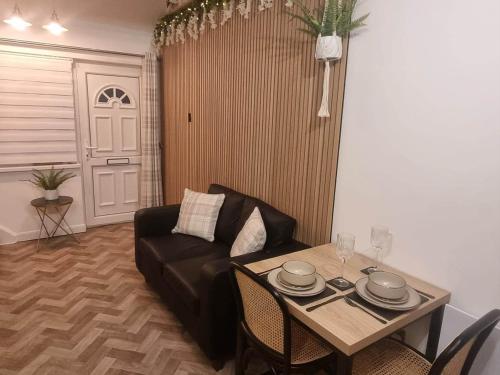 a living room with a couch and a table at Cosy Moat House Cottage #3 in Pembroke