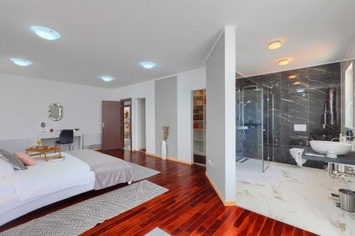 瑪圖爾伊的住宿－Villa Kelly Matulji，一间卧室配有一张床,浴室设有淋浴。
