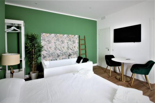 a living room with a white bed and a green wall at COMÓ EXCLUSIVE in Aprilia