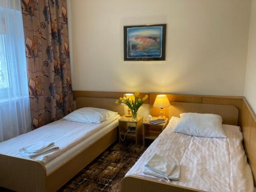 pokój hotelowy z 2 łóżkami i stołem z lampką w obiekcie Karat w Warszawie