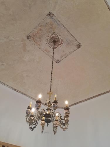 a chandelier hanging from the ceiling of a room at Palazzo AD 1892 - SUITES & SPA in Ostuni