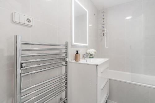 a white bathroom with a sink and a tub at Apartamento mediterráneo en el alma de Moraira in Moraira