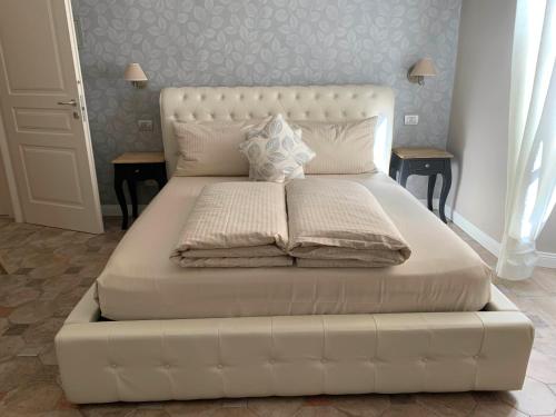 a large white bed in a bedroom with two tables at Spiaggia Amore - Appartamenti Vacanza Vista Lago - Luxury Apartments in Cannobio