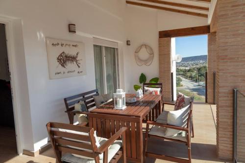 a dining room with a wooden table and chairs at Villa al vent (lujo & relax) in Benitachell