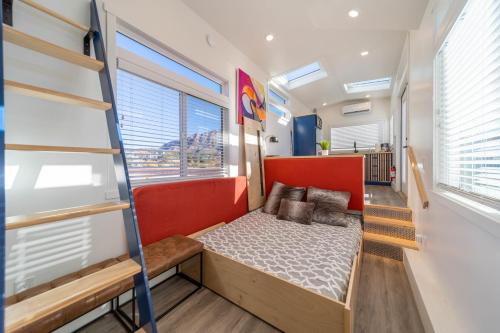 a small bedroom with a bed and a ladder at Cozy modern tiny home near ZION & private deck in Apple Valley