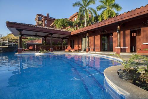una gran piscina frente a un edificio en Bougainvillea 8211 Luxury Apartment - Reserva Conchal, en Playa Conchal