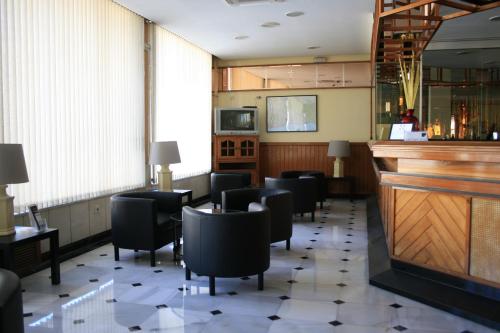 a bar with a bunch of chairs and a counter at Hotel el Paraiso in Caleta De Velez