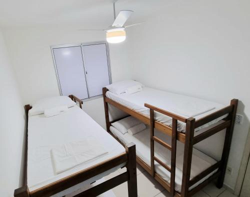 a room with two bunk beds and a ceiling fan at Apartamento aconchegante, em uma das praias mais bonitas do ES in Serra