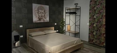 a bedroom with a large bed with a statue on the wall at Appartamento Villa Matilde in Borgata Zarattini